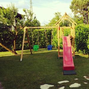 un parque infantil con tobogán y columpio en B&B Villa Monterosa con Piscina, en Castronno