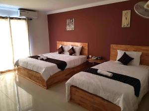 1 dormitorio con 2 camas y ventana en Lucky Hostel, en Battambang