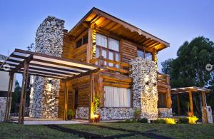 a log cabin with a large window and a porch at Cabañas Brisas del Jaguel in Santa Teresita