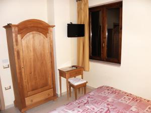 カプアにあるAgriturismo La Colombaiaのベッドルーム1室(ベッド1台付)、木製キャビネットが備わります。