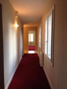an empty hallway with a red carpet and a window at Hôtel Cuulong in Labarthe-Inard +14 photos