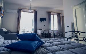 ein Schlafzimmer mit einem Bett mit blauen Kissen darauf in der Unterkunft Ulisse Maison de Charme in Sciacca