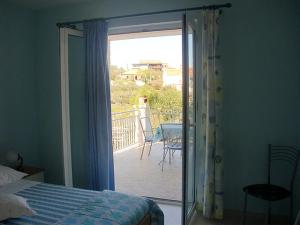 a bedroom with a sliding glass door to a balcony at Apartment Marina in Slatine