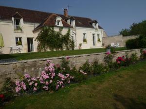 uma parede de retenção com flores em frente a uma casa em Villa Rosa em Saint-Georges-sur-Cher