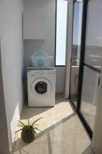 eine Waschmaschine in einem Zimmer mit Fenster in der Unterkunft St Joseph Penthouse in Victoria