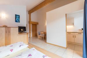 salon z łóżkiem i kuchnią w obiekcie Appartements Haus Pichler w mieście Eggen