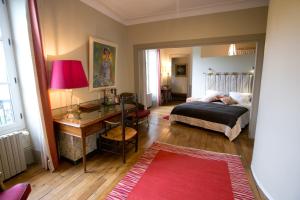 1 dormitorio con cama, escritorio y mesa en B&B Vassy Etaule, en Avallon