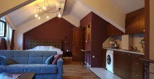 a living room with a blue couch and a kitchen at Studio Maison 3 Kapana in Plovdiv