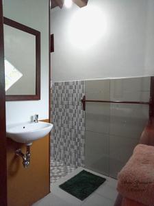 a bathroom with a sink and a shower with a mirror at Sam's Bungalows in Bukit Lawang