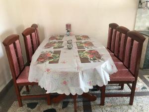 a dining room table with a white and pink table cloth at SUBI Home Stay in Kathmandu