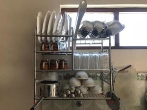 a shelf with dishes and utensils in a kitchen at SUBI Home Stay in Kathmandu