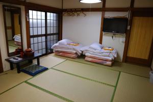 una habitación con una habitación con un montón de toallas en el suelo en Ryokan Sansuiso, en Tokio