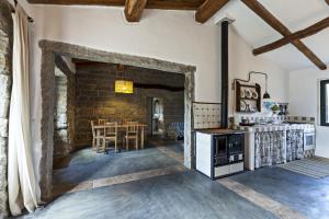 an open kitchen and dining room with a stone wall at Stazzo La Casedda in Luogosanto