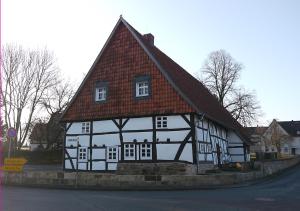 un bâtiment noir et blanc avec un toit rouge dans l'établissement Brunottescher Hof, à Wallenstedt