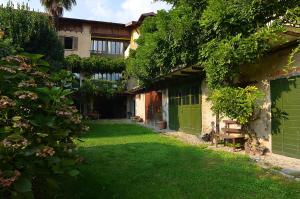 a yard with a building with a green door at Il Cortile - Casa d'Artista in Casalzuigno