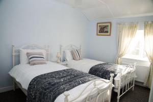 MalinにあるBarney's Lodgeのベッドルーム1室(ベッド2台、窓付)