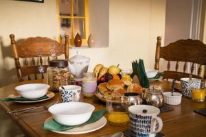 drewniany stół z miskami i talerzami żywności w obiekcie Barney's Lodge w mieście Malin