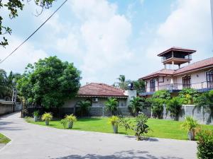 una casa con un cortile verde davanti di Sea Breeze Deluxe Inn a Negombo