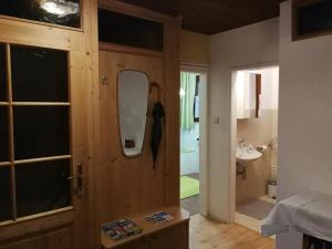 ein Badezimmer mit einer Holztür und einem Waschbecken in der Unterkunft Angi's Apartment in Sankt Lorenzen ob Murau