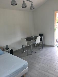 Zimmer mit einem Tisch, Stühlen und einem Bett in der Unterkunft A Casetta di Rosa in Corte