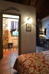 Il Cortile - Casa d'Artista في Casalzuigno: غرفة نوم بسرير وغرفة مع طاولة
