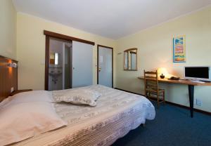 a bedroom with a bed and a desk with a computer at Auberge Le XIX eme in Thulin