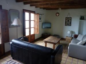 sala de estar con sofá y mesa en Can Pedragos, en Sales del Llierca