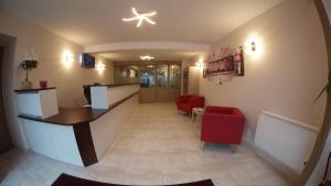 a hospital lobby with red chairs and a counter at Nevers Hotel in Nevers