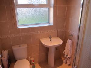 a bathroom with a sink and a toilet and a window at No 9 in Bognor Regis