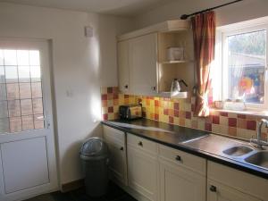 a small kitchen with a sink and a window at No 9 in Bognor Regis