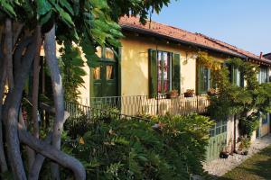 a house with a green door and some plants at Il Cortile - Casa d'Artista in Casalzuigno