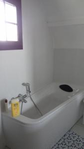 una vasca da bagno bianca in una stanza con finestra di Maison de vacances a Trévières Altre 21 foto
