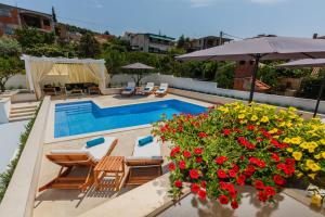 una piscina con un ramo de flores rojas al lado en Apartments And Studio Giovanni 1, en Trogir
