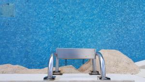 a silver chair sitting in front of a blue wall at Hal Saghtrija - Gozo Hideaways in Żebbuġ