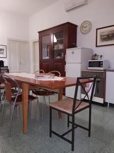 マテーラにあるB&B Nonna Rosariaのキッチン(木製テーブル、椅子、冷蔵庫付)