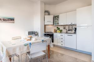 a kitchen with white cabinets and a table with chairs at Casa del Sole in Cagliari