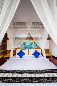 a bedroom with a bed with blue and white pillows at Sunset Paradise Jimbaran 3003 in Jimbaran +23 photos