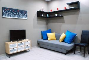 a living room with a couch with blue and yellow pillows at RHOMENJOY Suite Vatican in Rome