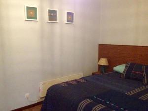 ポルト・コーヴォにあるCasa de Mar @ Porto Côvoのベッドルーム1室(ベッド1台付)が備わります。壁には絵画が飾られています。