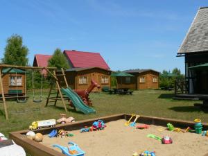 einen Spielplatz mit Spielzeug im Sand vor den Häusern in der Unterkunft Siedlisko Białogóra in Białogóra