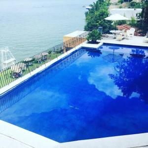 una grande piscina blu accanto all'oceano di Depa Teques a Tequesquitengo