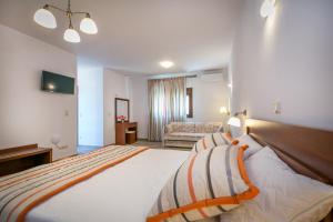 a hotel room with a large bed and a couch at Elaionas Stone Houses in Skala Potamias