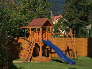 drewniany zestaw zabaw ze zjeżdżalnią i placem zabaw w obiekcie Willa Aleksandra - Apartamenty w Międzybrodziu Żywieckim