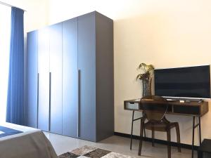 a bedroom with a desk with a television and a bed at Residenza Santa Lù B&B in Naples
