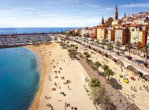 un grupo de personas en una playa cerca del agua en Etoile De Mer, en Menton