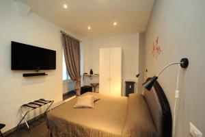 Schlafzimmer mit einem Bett und einem Flachbild-TV in der Unterkunft OneTime Roma in Rom