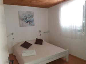 a white bedroom with a bed in a room at Apartment Nono Ivo in Vis