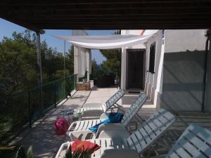 a group of chairs and tables on a patio at Apartment Nono Ivo in Vis
