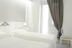 ローマにあるGens Claudia, Vatican Luxury Apartmentsの白いベッドルーム(ベッド2台、椅子付)