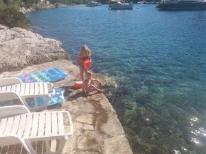 a girl and a child sitting on the edge of the water at Apartment Nono Ivo in Vis